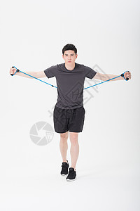 阻力训练青年男子使用阻力带健身塑身背景