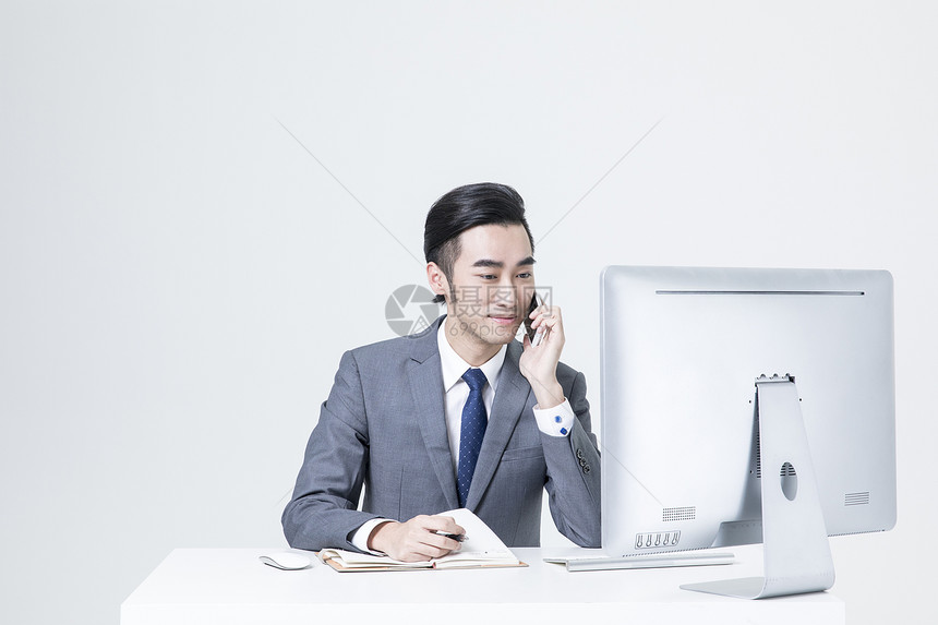 一边工作一边打电话的商务男士图片