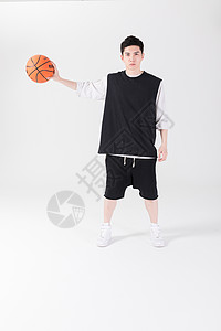 拿着篮球打篮球的年轻男生背景图片