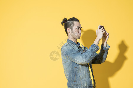 拿着相机拍照的青年男性背景图片