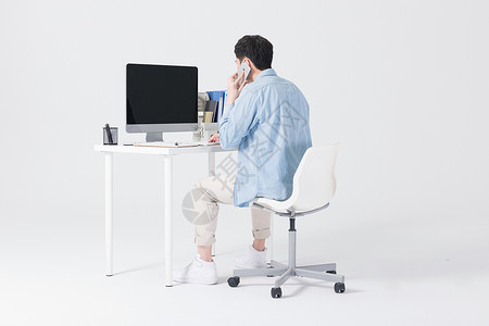 休闲商务男性办公桌坐着打电话图片