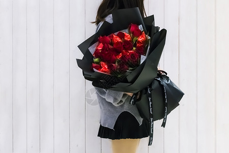 浅灰色背景图抱玫瑰花束的女孩背景