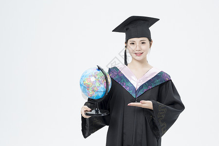 拿着地球仪的毕业女大学生图片