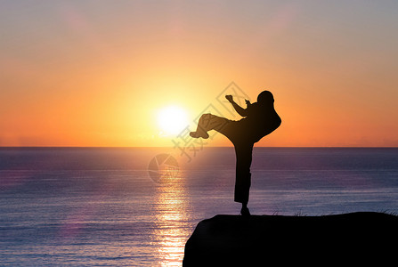 男孩打泰拳夕阳下的武术剪影设计图片