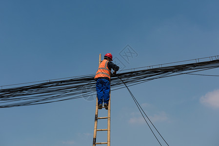 工人背着电线蓝天下维修线路的工人背景
