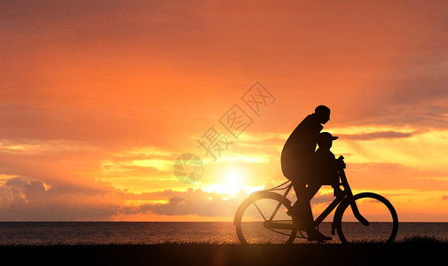 父亲骑车带小孩夕阳下的父子剪影设计图片