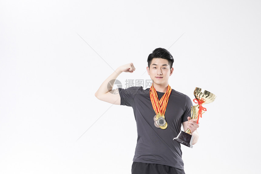 戴着奖牌拿着奖杯运动男性图片