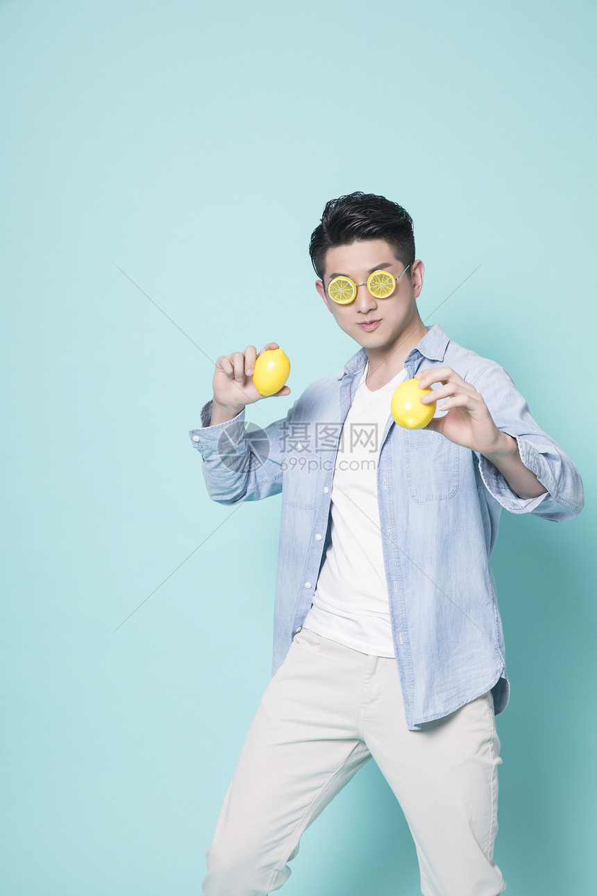 拿着柠檬的青年男性图片