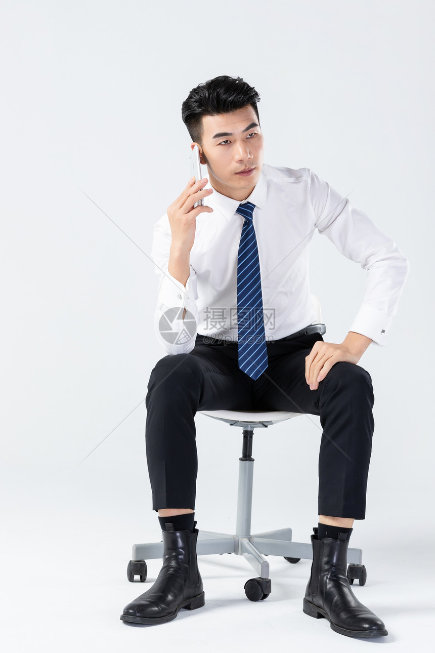 商务男士坐椅上打电话图片