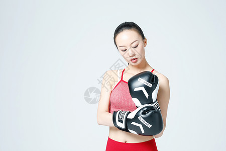 健身女性戴拳击手套展示动作图片