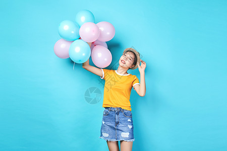 好看的黄色气球青年活力女性手持彩色气球背景