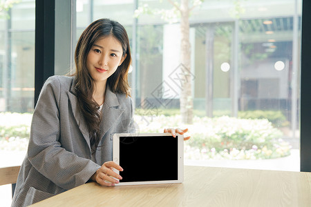 商务女性咖啡馆手持平板电脑图片