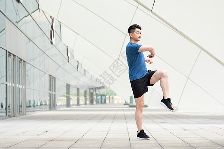 年轻男性户外运动热身拉伸动作图片