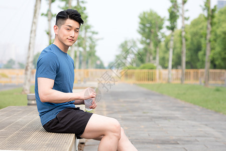 运动后坐着休息喝水放松的年轻男性图片