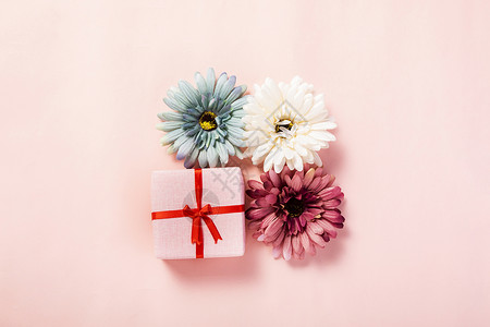 粉色背景上的礼盒鲜花图片