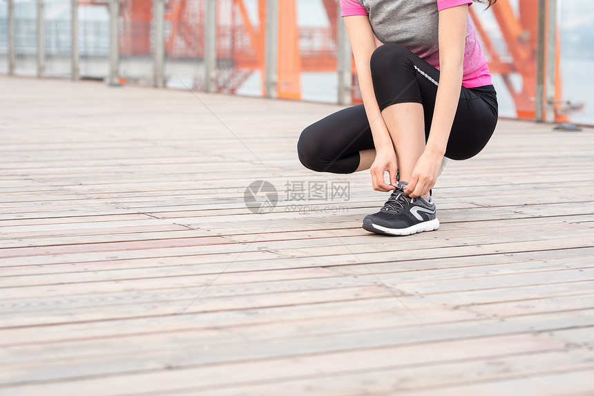 户外运动女性蹲下系鞋带图片