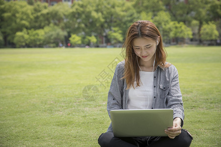 女学生在大学草坪上学习图片