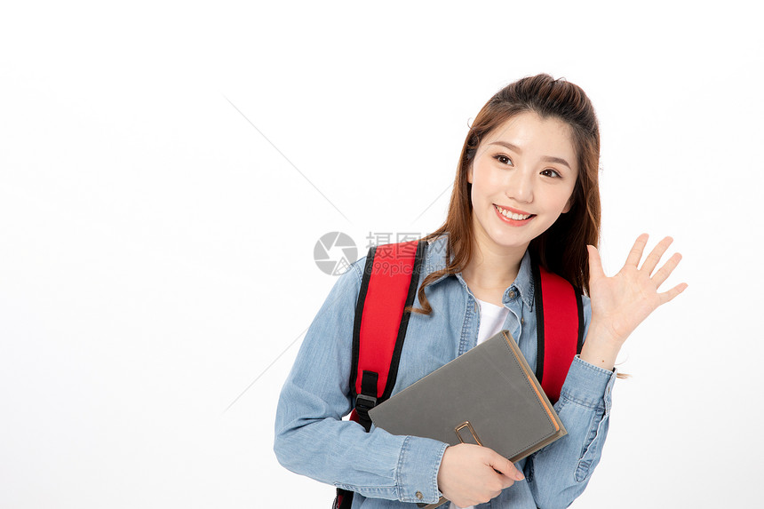 背着书包拿书本的女大学生图片
