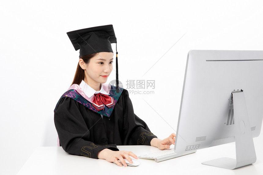 电脑前微笑的毕业生图片