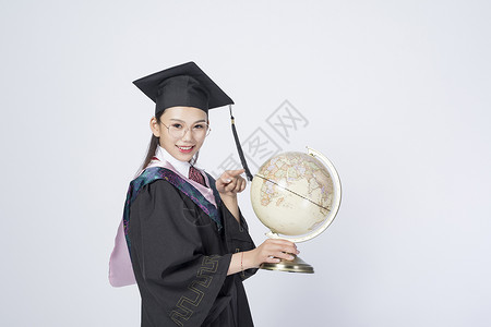 拿着地球仪的毕业女学生图片