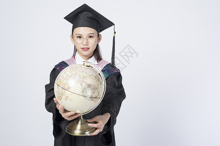 拿着地球仪的毕业女学生图片