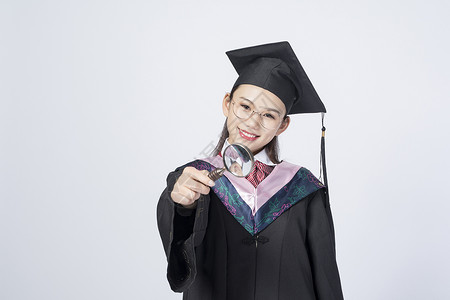 拿着放大镜的毕业女学生图片