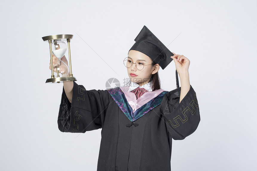 拿着沙漏的毕业女学生图片