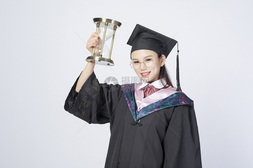 拿着沙漏的毕业女学生图片