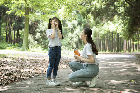 小孩倒水户外妈妈给孩子倒水背景