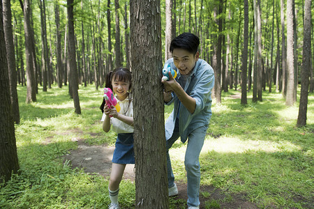 与乌龟春游爸爸与孩子在树林中玩水枪背景