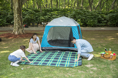 一家人在露营时铺野餐垫高清图片