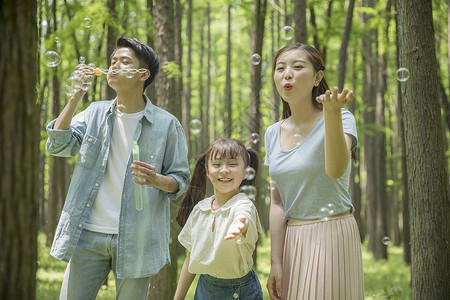 六一儿童节一家人在森林公园吹泡泡图片