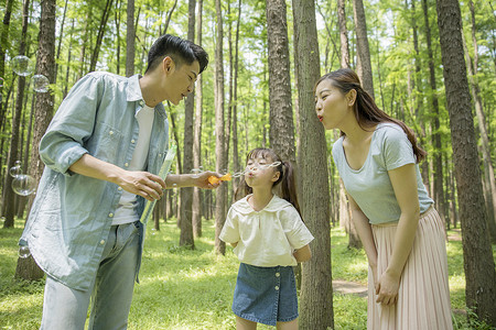 一家人在森林公园吹泡泡背景图片