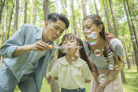 一家人在森林公园吹泡泡高清图片