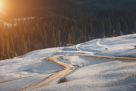 在阳光下雪山里蜿蜒的路背景图片