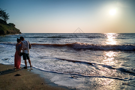 情侣看海豚涠洲岛海滩欣赏日落的情侣背景