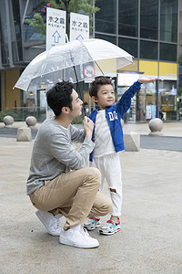 帮儿子打伞的父亲高清图片