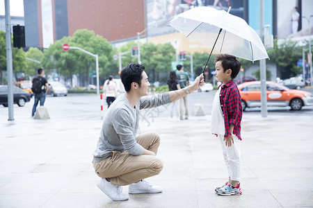 父子在雨中父爱打伞高清图片