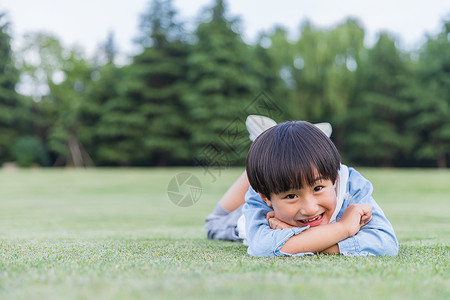 可爱儿童开心趴在草地上高清图片