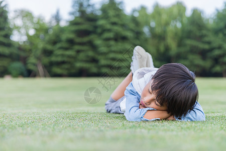 可爱儿童趴在草地上休息背景图片