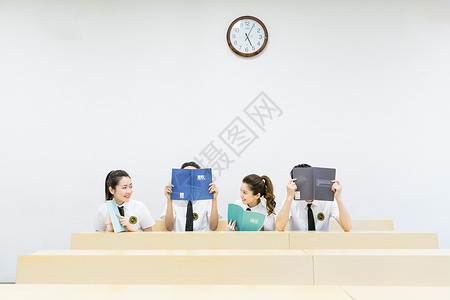 创意笑脸坐在教室里手拿课本微笑的同学们背景