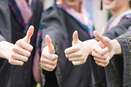 毕业生自拍穿学士服的毕业生点赞竖大拇指自拍背景