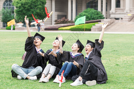穿学士服坐在开心坐在草地上的大学生图片