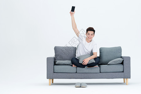 青年男性客厅沙发玩手机图片