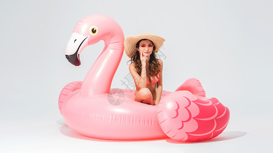 蓝褐色遮阳帽穿粉色比基尼的可爱卖女坐在火烈鸟游泳圈背景