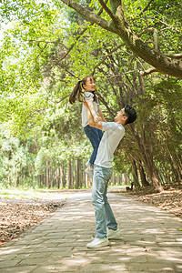 公园里父亲抱起孩子背景图片