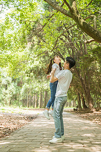 公园里父亲抱起孩子高清图片