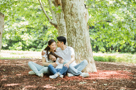 一家人坐在大树下休息背景图片