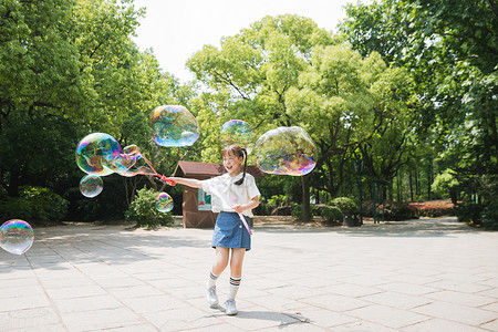 公园里可爱女孩玩吹泡泡背景图片