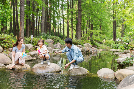 一家人小河上玩水枪背景图片